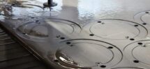Wasserstrahl schneidet kreisförmige Konturen in eine dicke Metallplatte