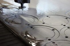 Wasserstrahl schneidet kreisförmige Konturen in eine dicke Metallplatte