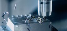 CNC-Bearbeitung eines Metallblocks mit glänzendem Werkzeug
