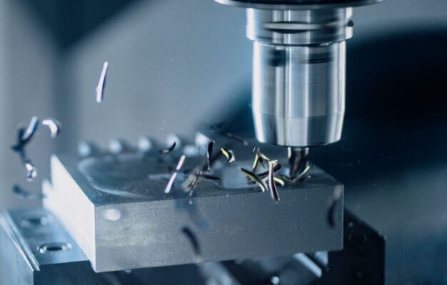 CNC-Bearbeitung eines Metallblocks mit glänzendem Werkzeug