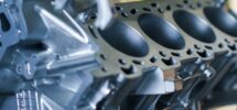 Nahaufnahme eines gelochten Aluminiumbauteils mit dunklen Oberflächenbereichen