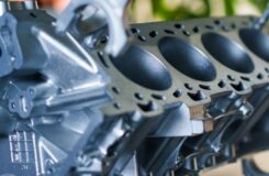 Nahaufnahme eines gelochten Aluminiumbauteils mit dunklen Oberflächenbereichen