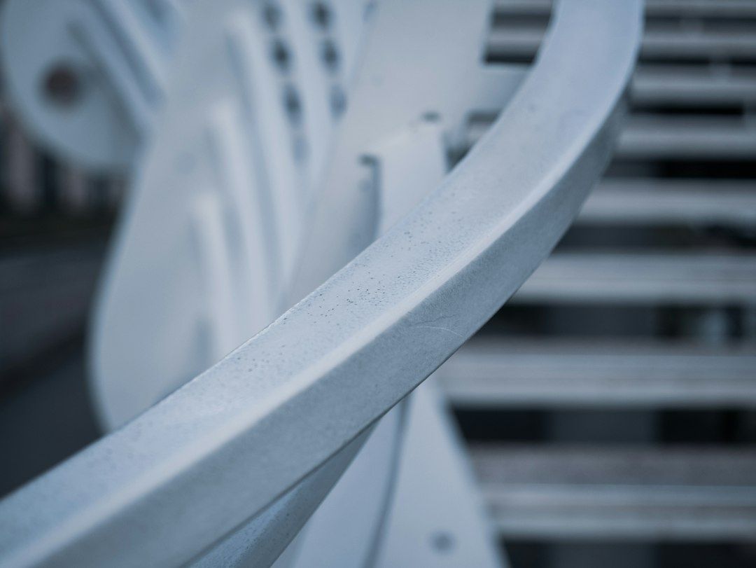 Nahaufnahme einer hell beschichteten Metallschiene vor technischen Bauteilen